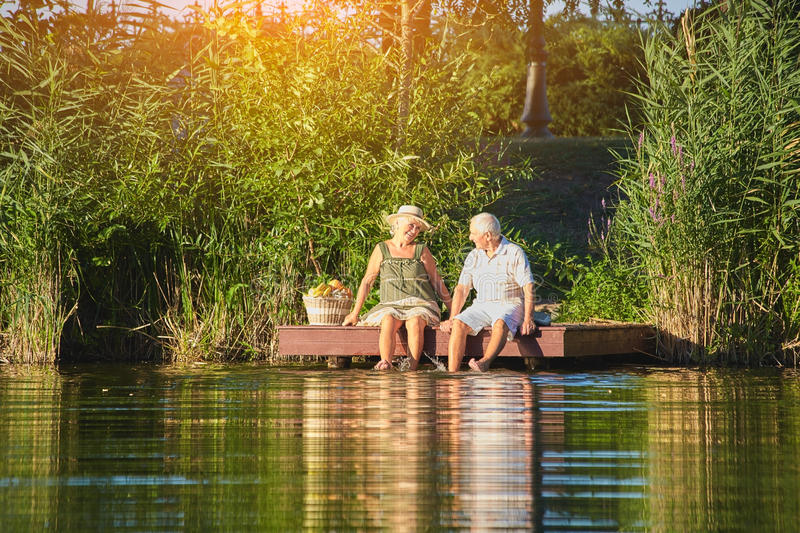Elder couple sittings outdoors on a dock